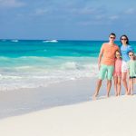 Portrait of happy beautiful family of four on a tropical beach on Carribean vacation